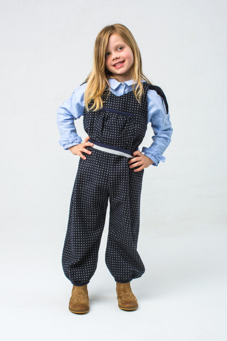 Kinder-Jumpsuit aus Wollstoff mit Schleifen an den Schultern und gesmokter Tasche, Schnittmuster von Initiative Handarbeit